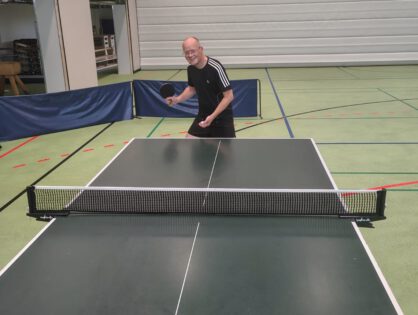 Mensch, der Tischtennis spielt und Aufschlag hat